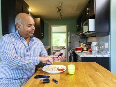 Person checking blood glucose before healthy meal at home