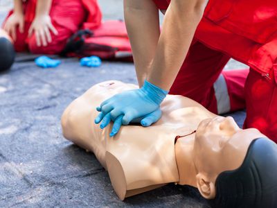 Midsection Of Man With Cpr Dummy During Training