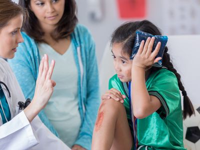 a girl with head injury being checked by doctor