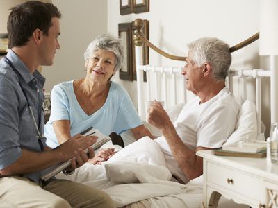 man at home in bed with his wife and doctor