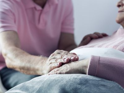 Man holding elderly woman's hand