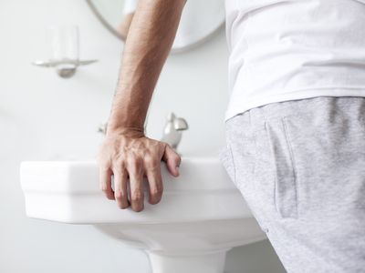 Man leaning against bathroom sink