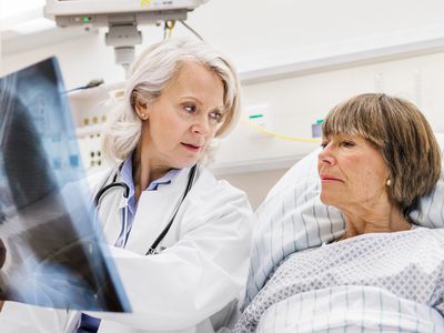 Mature Female Doctor Checking X-Ray With Mature Patient