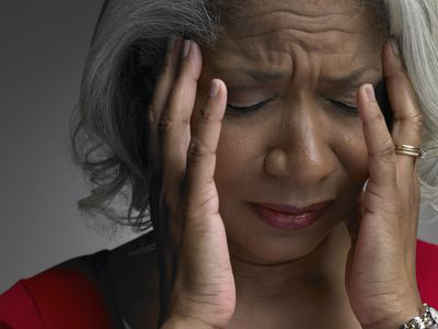 Mature woman with head in hands and eyes closed, close-up