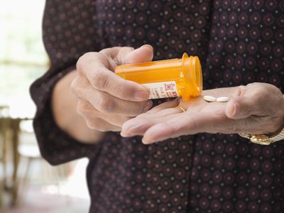 Mixed race woman holding medication pills