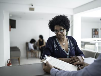 Patient talking to the secretary at hospital reception