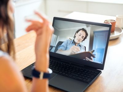 Psychologist making notes during online session with patient