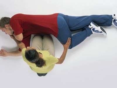 woman putting man into recovery position