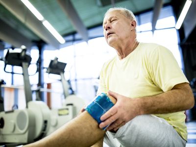 Senior man holding ice pack on knee