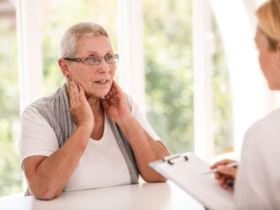 Senior woman complaining to her doctor about her tonsils