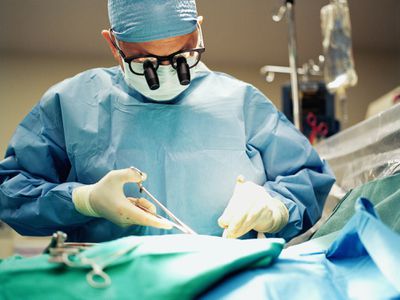 Surgeon closing stitches on a patient