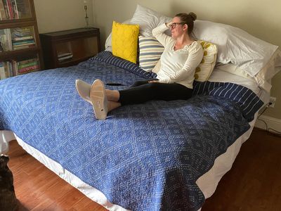 A person lays on the Purple Ascent Adjustable Base bed