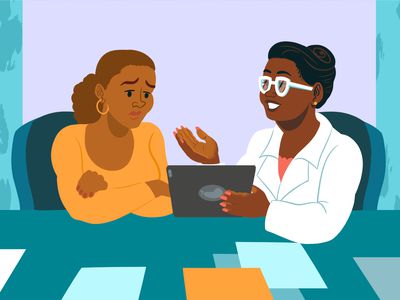 A healthcare provider sitting next to a person showing them information