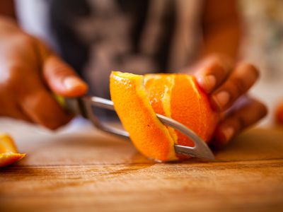 Close up of an orange peel being cut