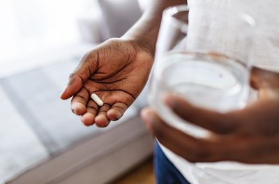 A woman with one white capsule.