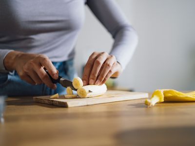 Woman cutting a banana to eat