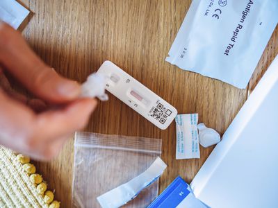 A woman using Covid-19 rapid self-test kit at home