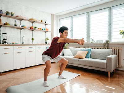 Young Man Doing Squats At Home