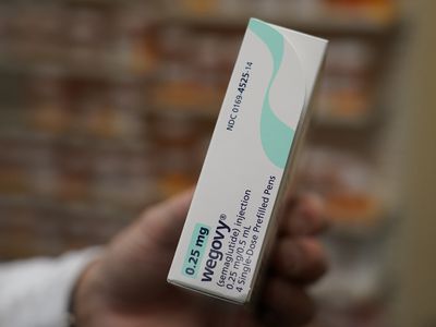 A close up of a pharmacist's hand holding a box of a 0.25 mg Wegovy injection medication