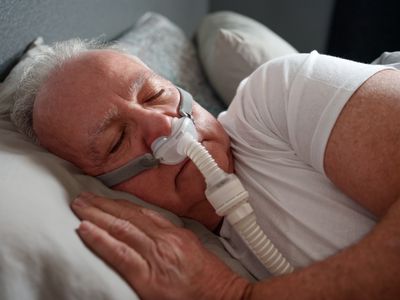 man sleeping with a CPAP machine