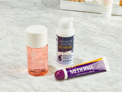 Three different types of scar creams we recommended on a marble counter.