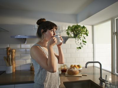 Woman drinking from mug in zero waste kitchen.